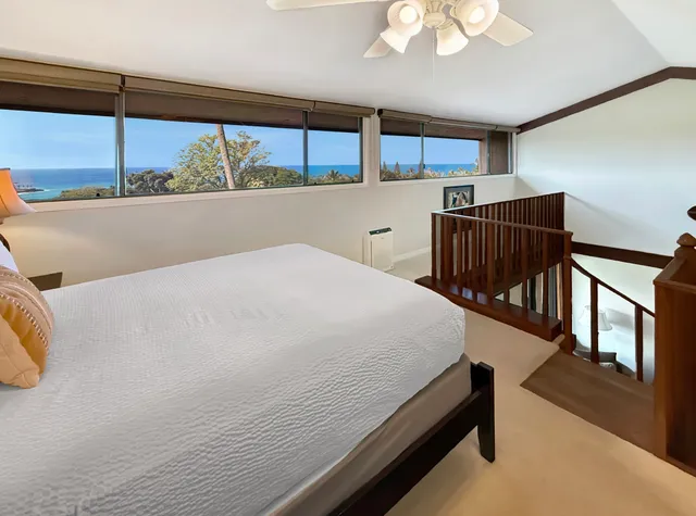 a bedroom with a large bed and windows