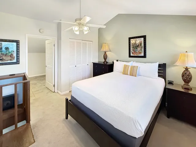 a spacious bedroom with a bed a table and painting on the wall