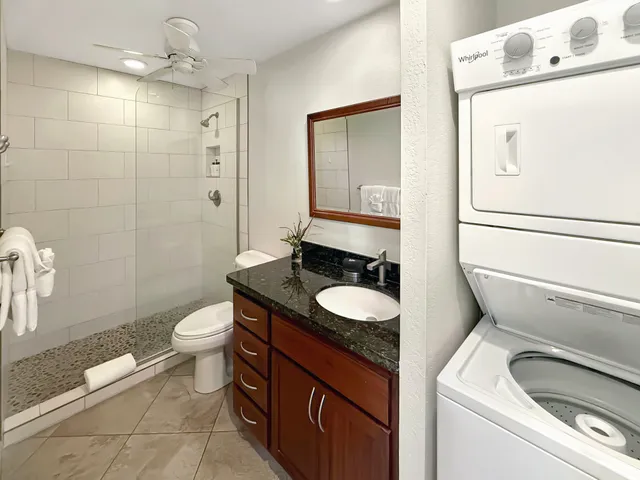 a bathroom with a granite countertop toilet sink and mirror