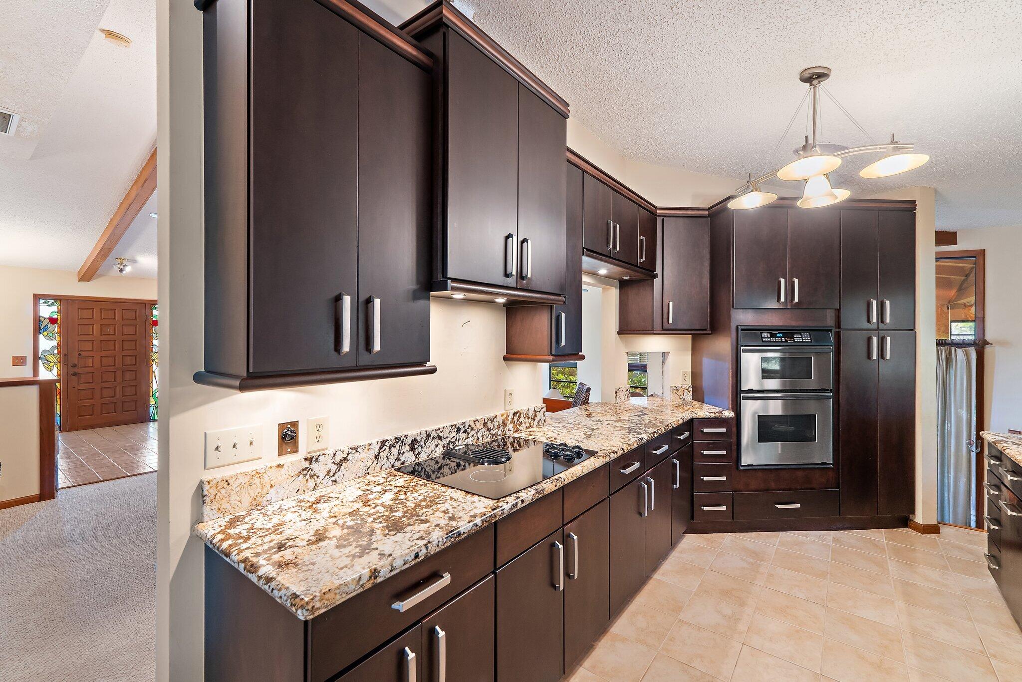702 Warren Drive Jupiter, FL 33458 - Photo 43 of 76 a kitchen with stainless steel appliances granite countertop a sink stove and refrigerator
