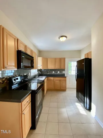 a kitchen with a refrigerator and a stove top oven