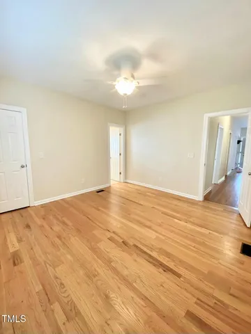 a view of empty room with wooden floor