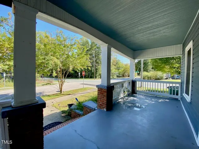 a view of a porch with chairs and backyard of the house