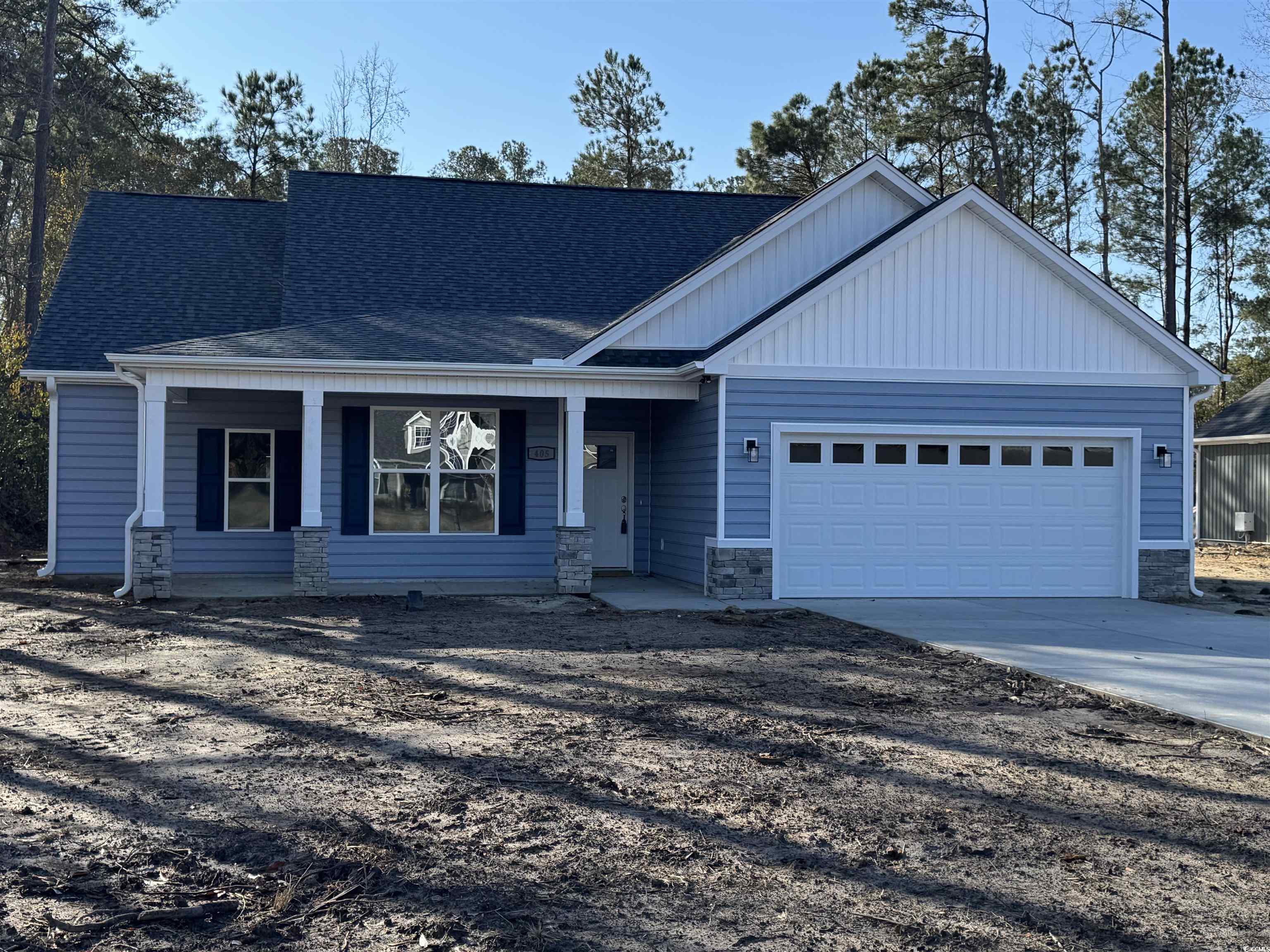 View of front facade featuring a porch, concrete driveway, a shingled roof, and stone siding