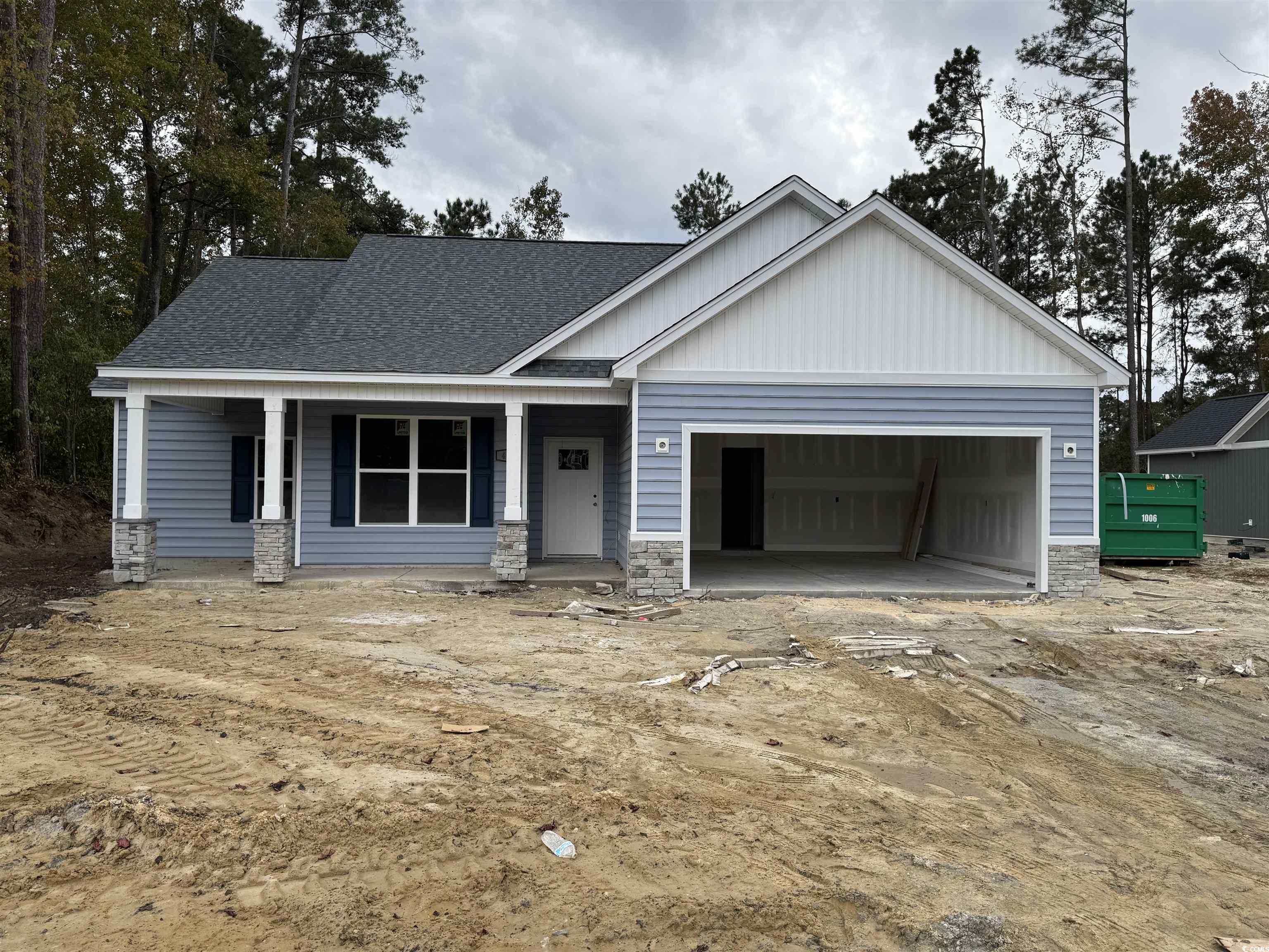 405 St John Road Aynor, SC 29544 - Photo 2 of 16 View of front of property featuring a porch, stone siding, an attached garage, board and batten siding, and roof with shingles