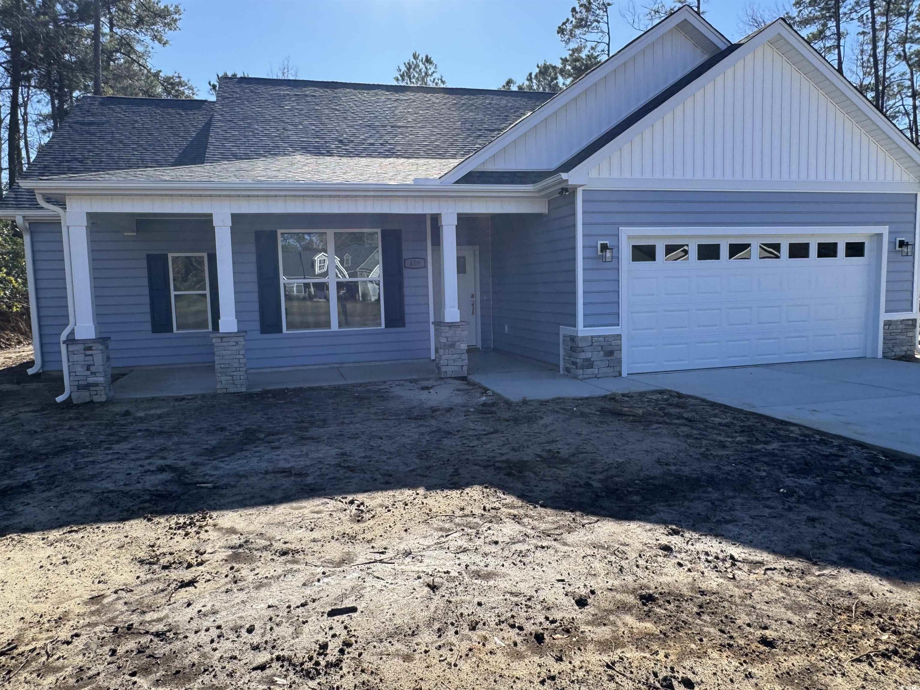 405 St John Road Galivants Ferry, SC 29544 - Photo 2 of 16 View of front facade with a porch, stone siding, a shingled roof, board and batten siding, and driveway