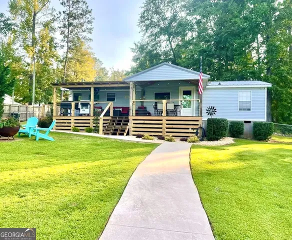 a front view of a house with swimming pool and furniture