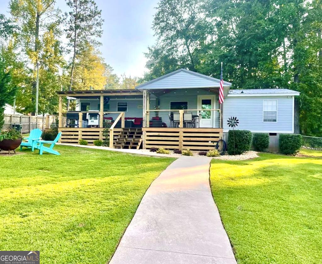 a front view of a house with swimming pool and furniture