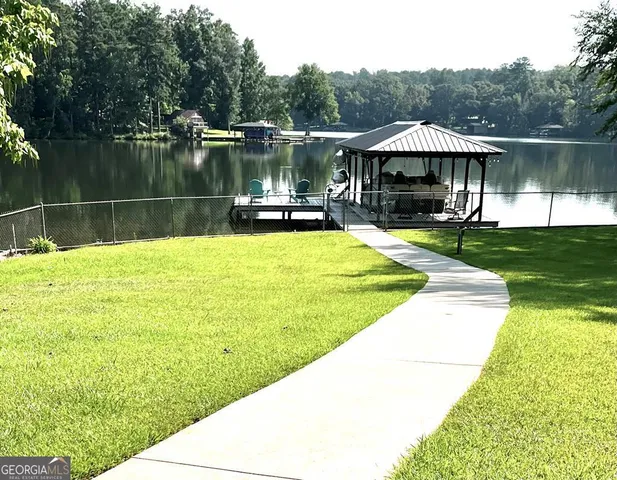a view of a swimming pool with a table and chairs under an umbrella