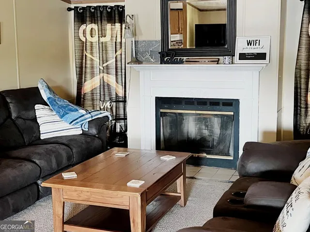 a living room with furniture a flat screen tv and a fireplace