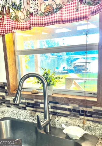 a view of a living room with a floor to ceiling window and wooden floor