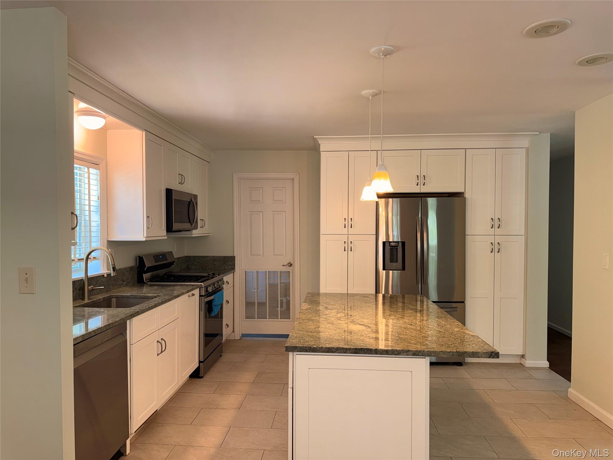 1661 Old Country Road, Unit 516 Riverhead, NY 11901 - Photo 15 of 50 a kitchen with stainless steel appliances granite countertop a sink and a refrigerator