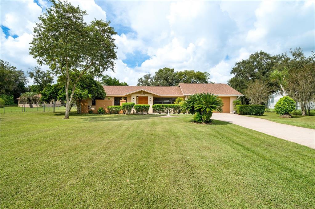 a view of an house with swimming pool and yard
