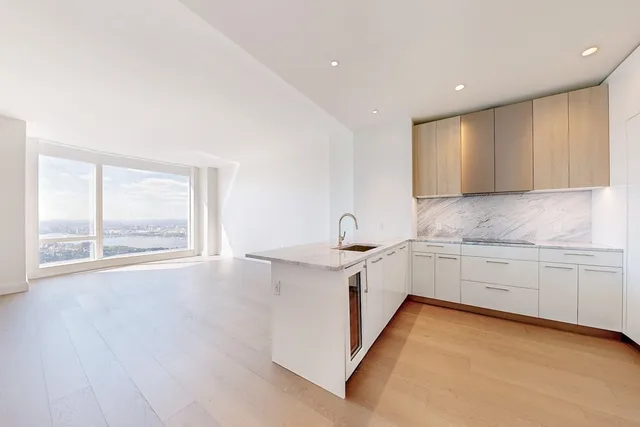 a large kitchen with granite countertop a sink and a stove top oven