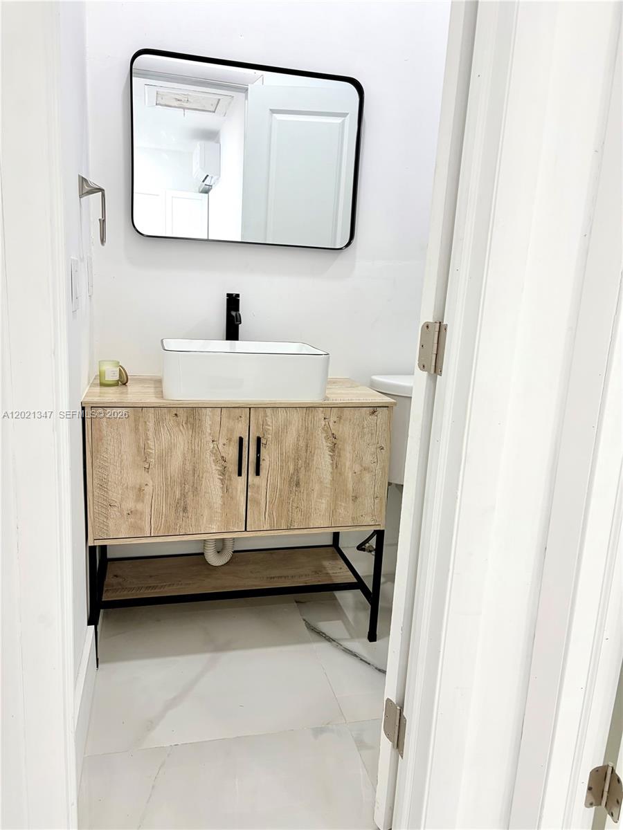 13065 Southwest 263rd Terrace, Unit 2 Homestead, FL 33032 - Photo 9 of 15 a bathroom with a sink and a mirror