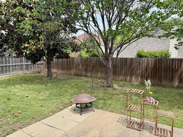 a backyard of a house with table and chairs