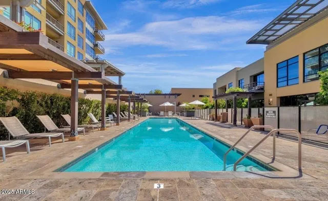 a view of a house with backyard swimming pool and sitting area