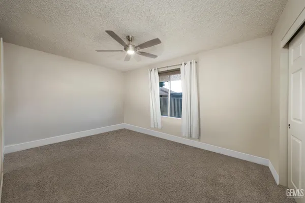 an empty room with a empty space and a ceiling fan