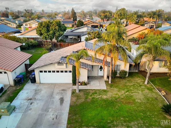 an aerial view of residential houses with outdoor space and trees