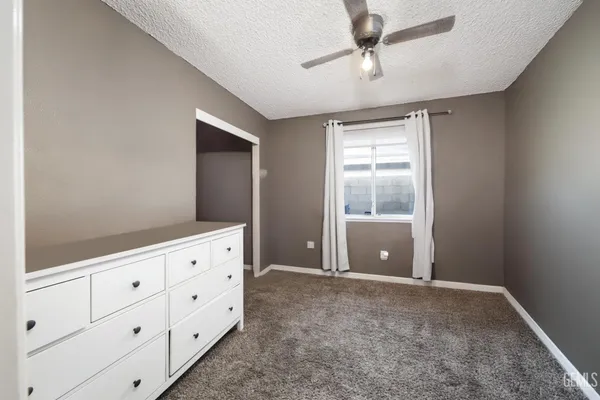 a view of an empty room with window and cabinet