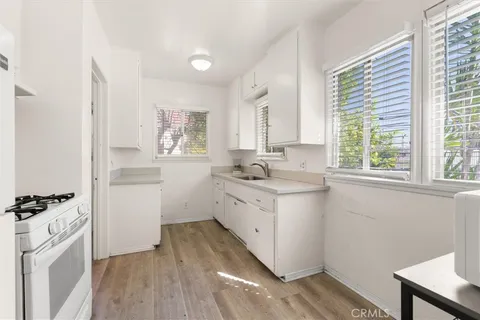 a kitchen with a white cabinets and wooden floor