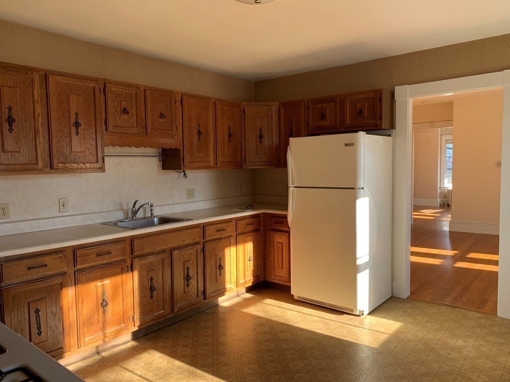 5 Plain Street Natick, MA 01760 - Photo 11 of 31 a kitchen with stainless steel appliances granite countertop a refrigerator and a sink