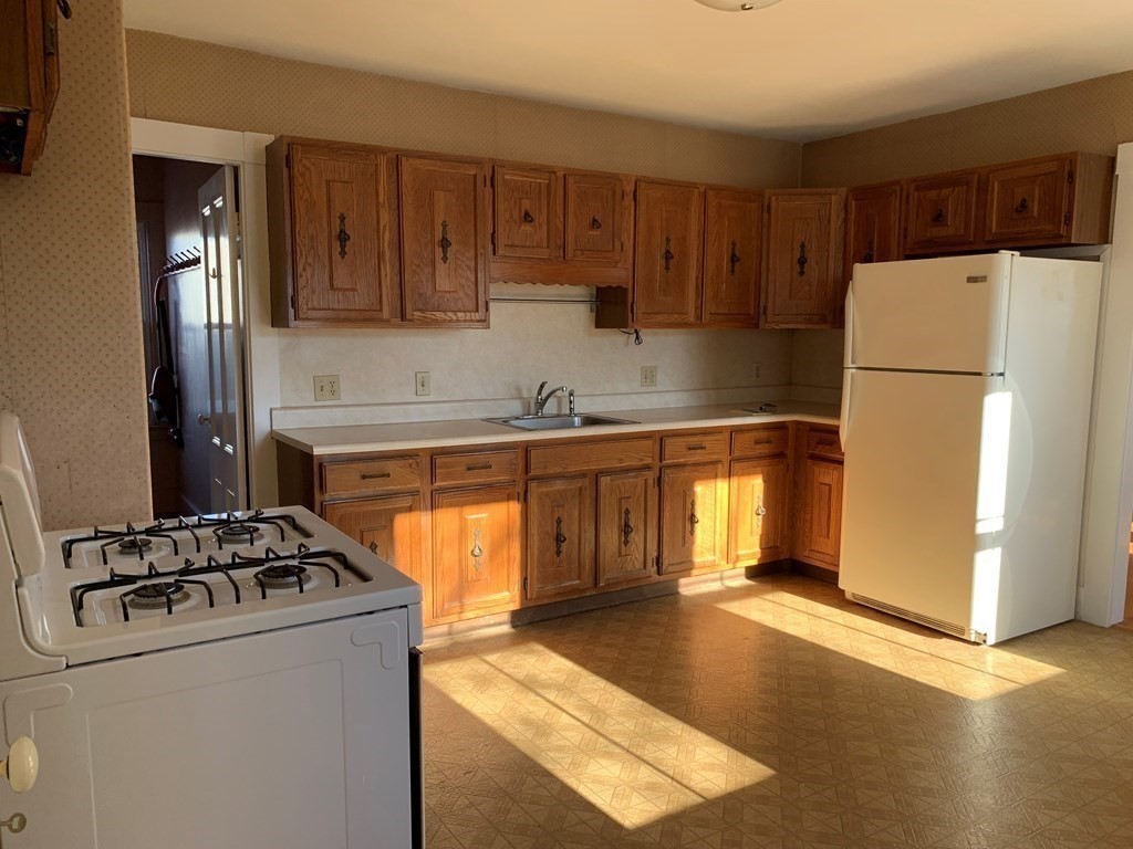 5 Plain Street Natick, MA 01760 - Photo 12 of 31 a kitchen with stainless steel appliances granite countertop a refrigerator stove sink and cabinets