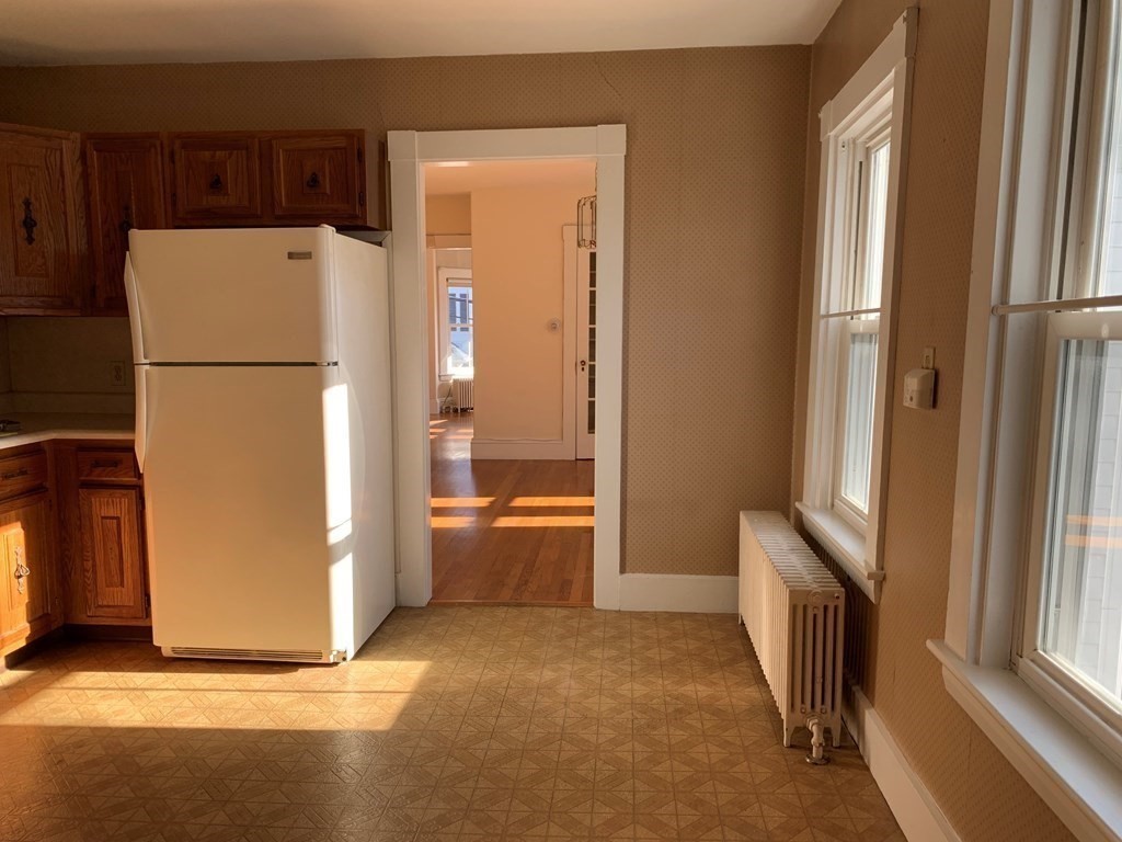 5 Plain Street Natick, MA 01760 - Photo 13 of 31 a view of a kitchen with a refrigerator a microwave a sink and a large window