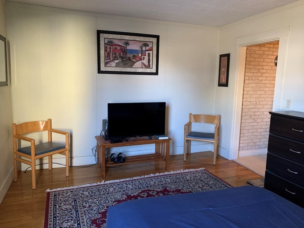 5 Plain Street Natick, MA 01760 - Photo 26 of 31 a living room with furniture and a flat screen tv