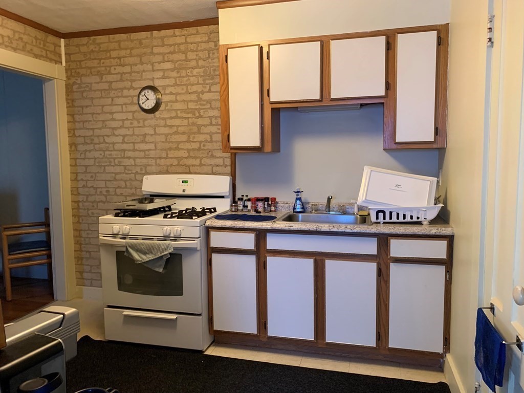 5 Plain Street Natick, MA 01760 - Photo 29 of 31 a kitchen with stainless steel appliances granite countertop a stove and a microwave