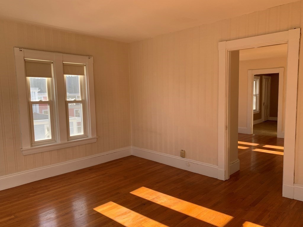 5 Plain Street Natick, MA 01760 - Photo 7 of 31 a view of an empty room with wooden floor and a window