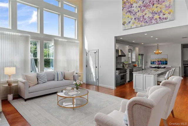 a living room with furniture kitchen and a large window