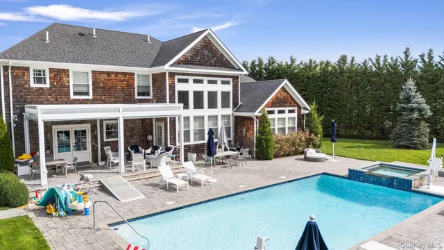 a front view of a house with swimming pool having outdoor seating