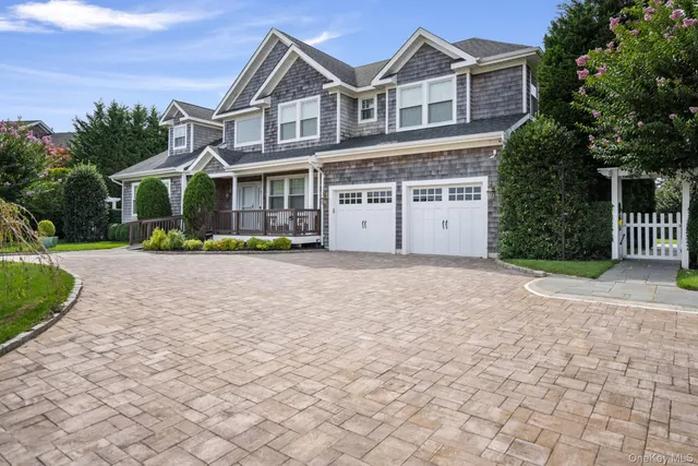 a view of a white house with a yard and plants