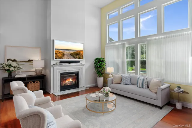 a living room with furniture fireplace and a large window