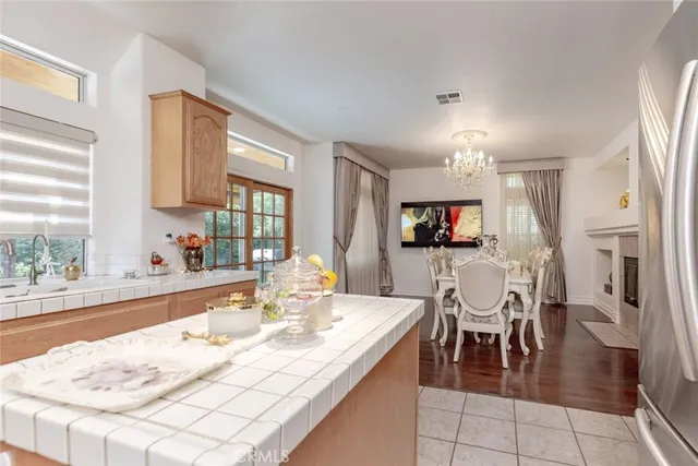 a dining hall with stainless steel appliances kitchen island granite countertop a table and chairs in it