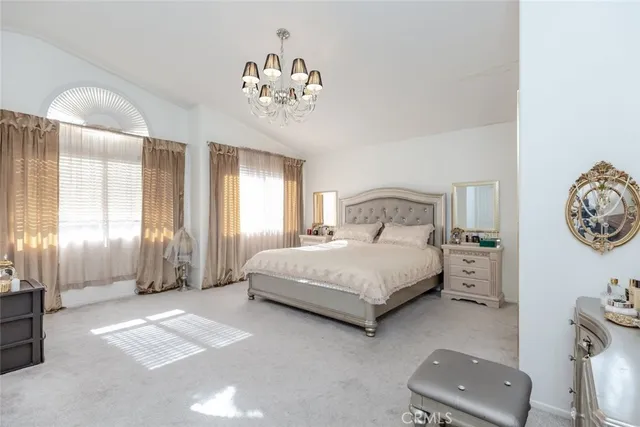 a spacious bedroom with a bed and a chandelier