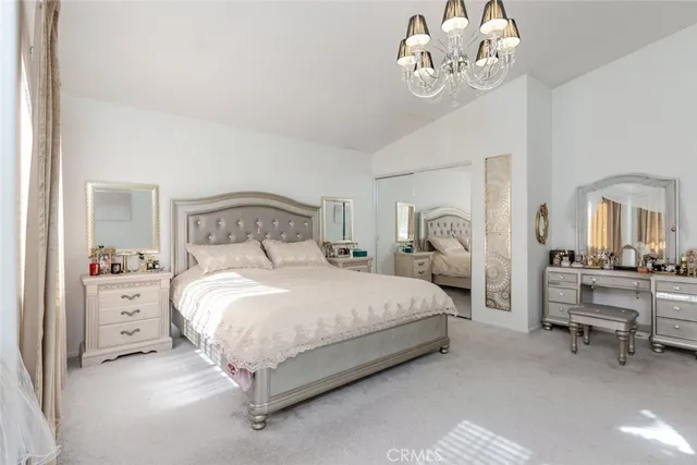 a bedroom with bed and a chandelier