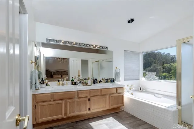 a bathroom with a double vanity sink a mirror and a bathtub
