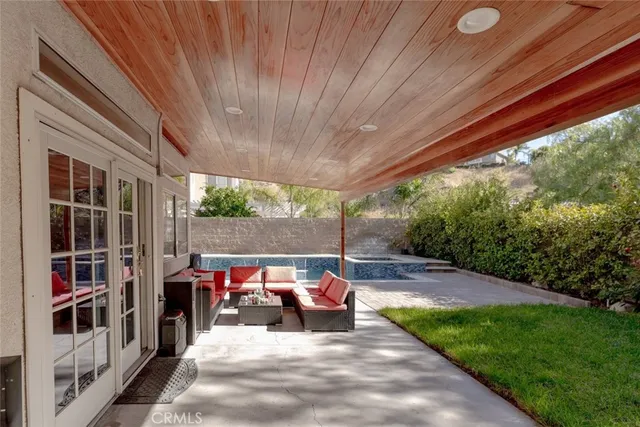 a view of a patio with table and chairs under an umbrella with a patio