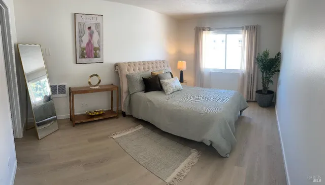 a bedroom with a bed and a painting on the wall