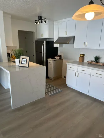 a kitchen with stainless steel appliances granite countertop a refrigerator a stove and a sink