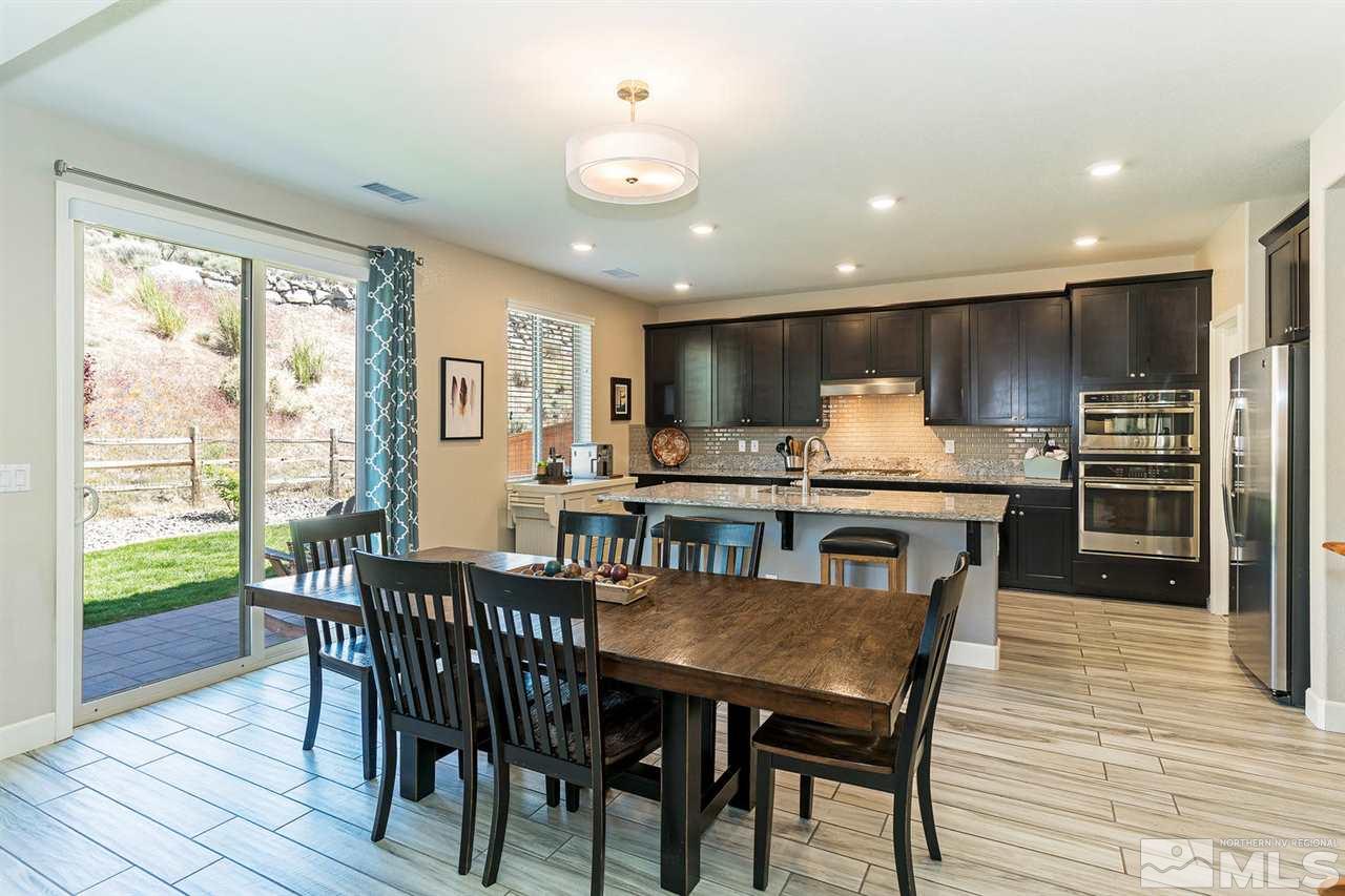 1650 Scott Valley Road Reno, NV 89523 - Photo 5 of 25 a kitchen with stainless steel appliances granite countertop a stove a refrigerator a kitchen island a table and chairs