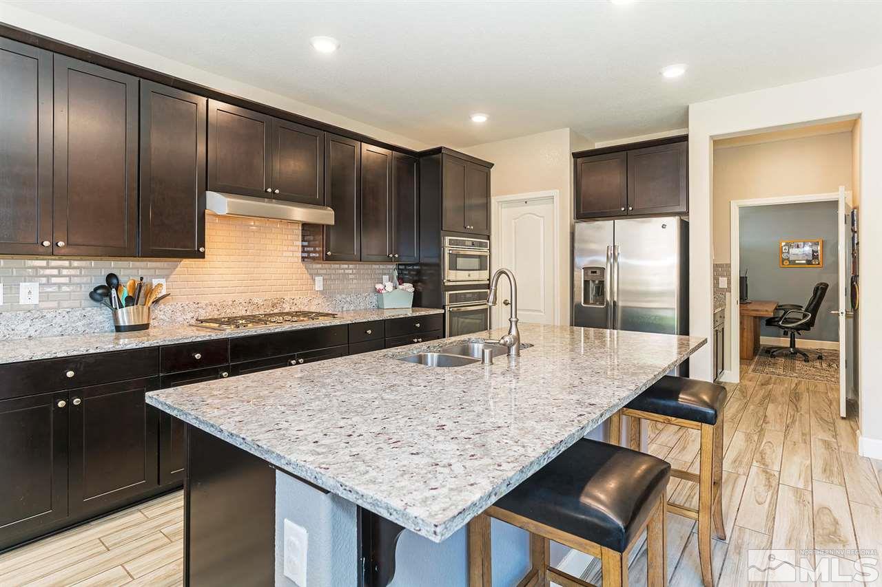1650 Scott Valley Road Reno, NV 89523 - Photo 7 of 25 a kitchen with kitchen island granite countertop wooden cabinets and refrigerator