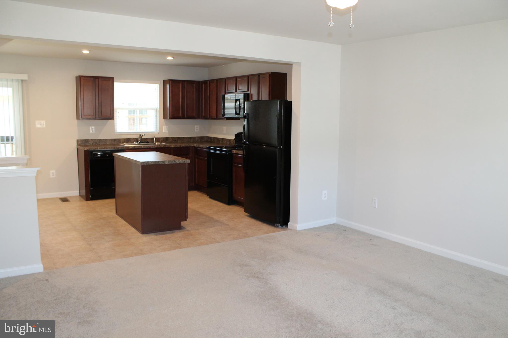 104 Reign Way Winchester, VA 22603 - Photo 11 of 27 a kitchen with a refrigerator and a stove top oven