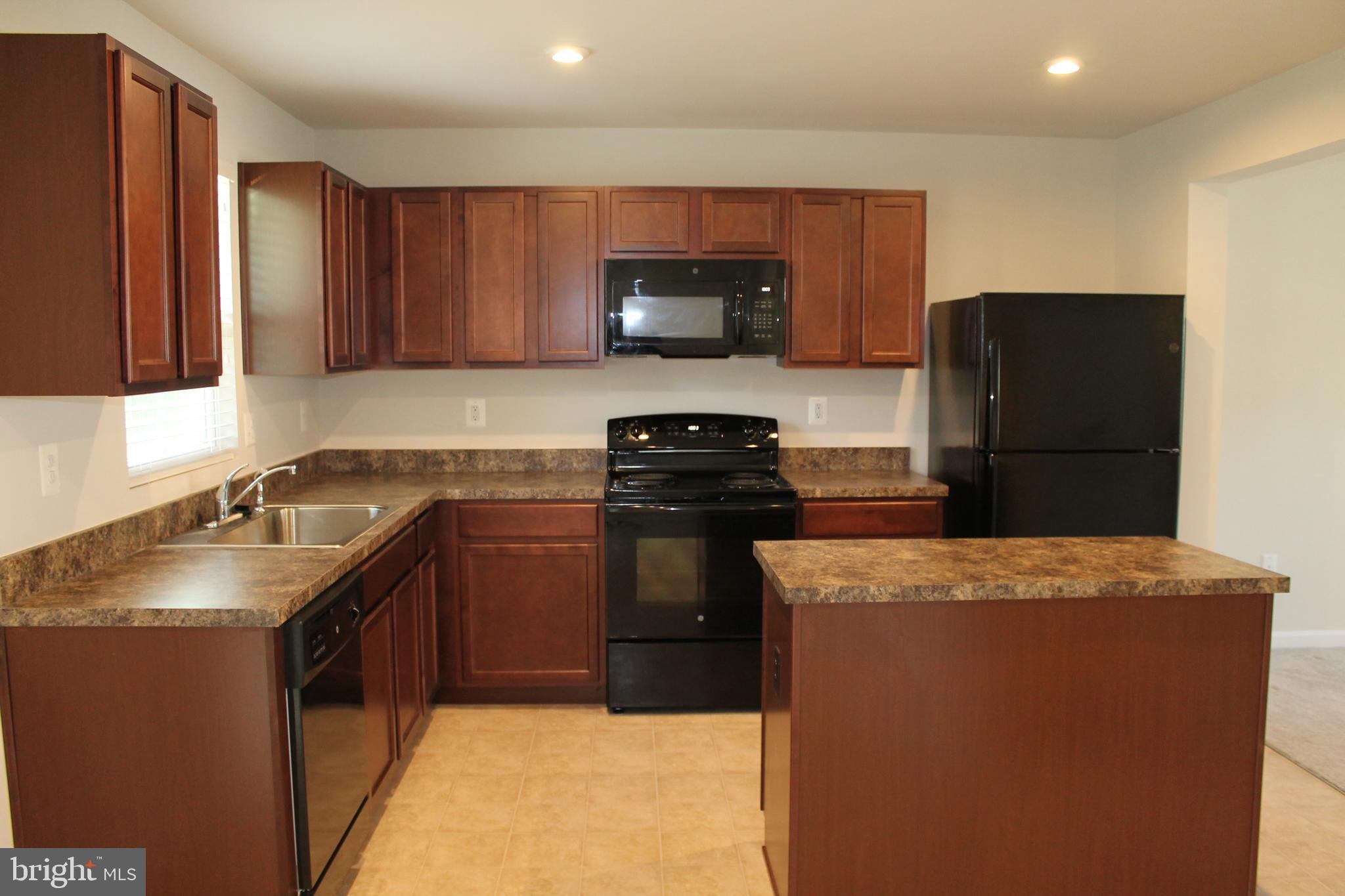 104 Reign Way Winchester, VA 22603 - Photo 6 of 27 a kitchen with a sink and a refrigerator