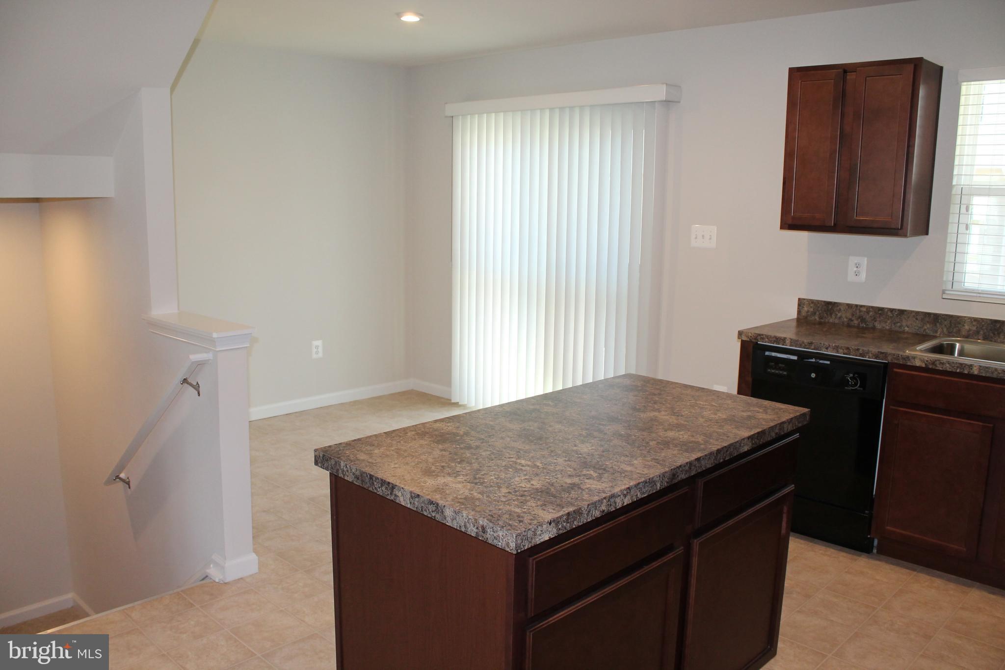 104 Reign Way Winchester, VA 22603 - Photo 8 of 27 a kitchen with a stove and a wooden cabinets
