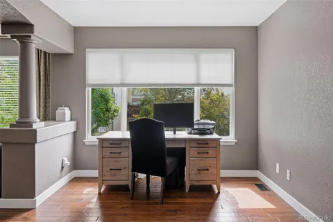 a view of a workspace with furniture and a window