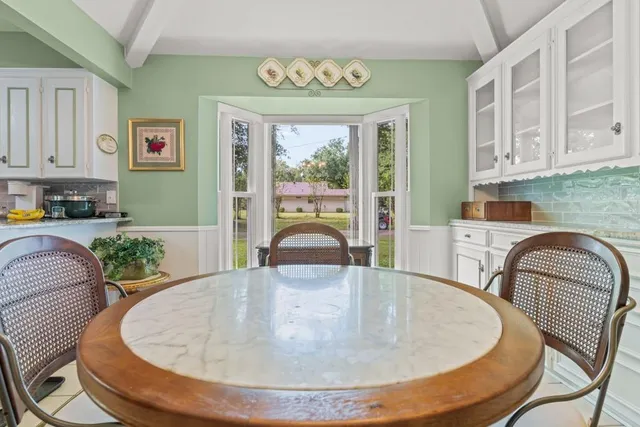 a dining table with chairs and window