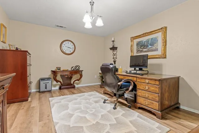 a view of a workspace with furniture and a window